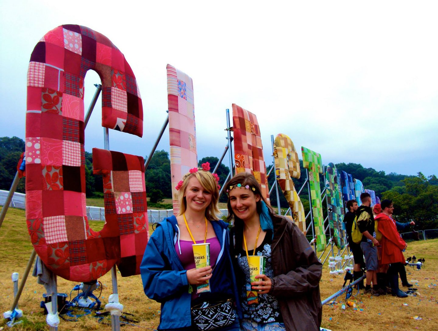Girls in front of the Glastonbury sign