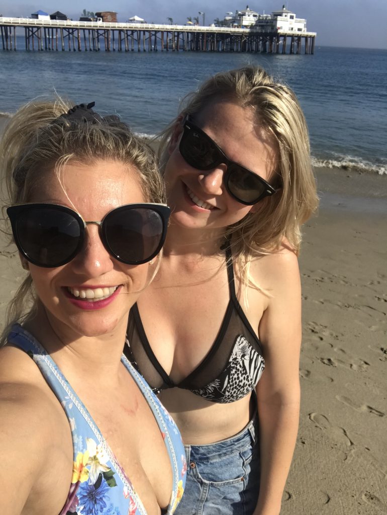 Girls on the beach with Malibu Pier, California